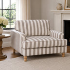 A classic striped armchair in soft neutral tones is beautifully styled in a bright, timeless living room, creating a warm and inviting space for everyday comfort.