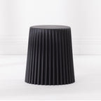 Black fluted side table with a round top, photographed on a white background.