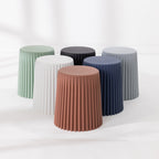 Six fluted side tables arranged together in green, black, grey, white, navy and tan on a white background.