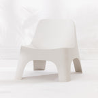 A modern moulded plastic chair in a cream colour.