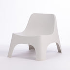 A modern moulded plastic chair in a cream colour.