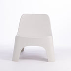 A modern moulded plastic chair in a cream colour.