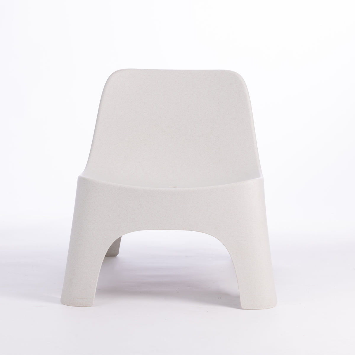 A modern moulded plastic chair in a cream colour.