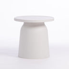 A minimalist, modern side table with a round top and a tapered, flared base, finished in a speckle texture, set against a seamless white background.