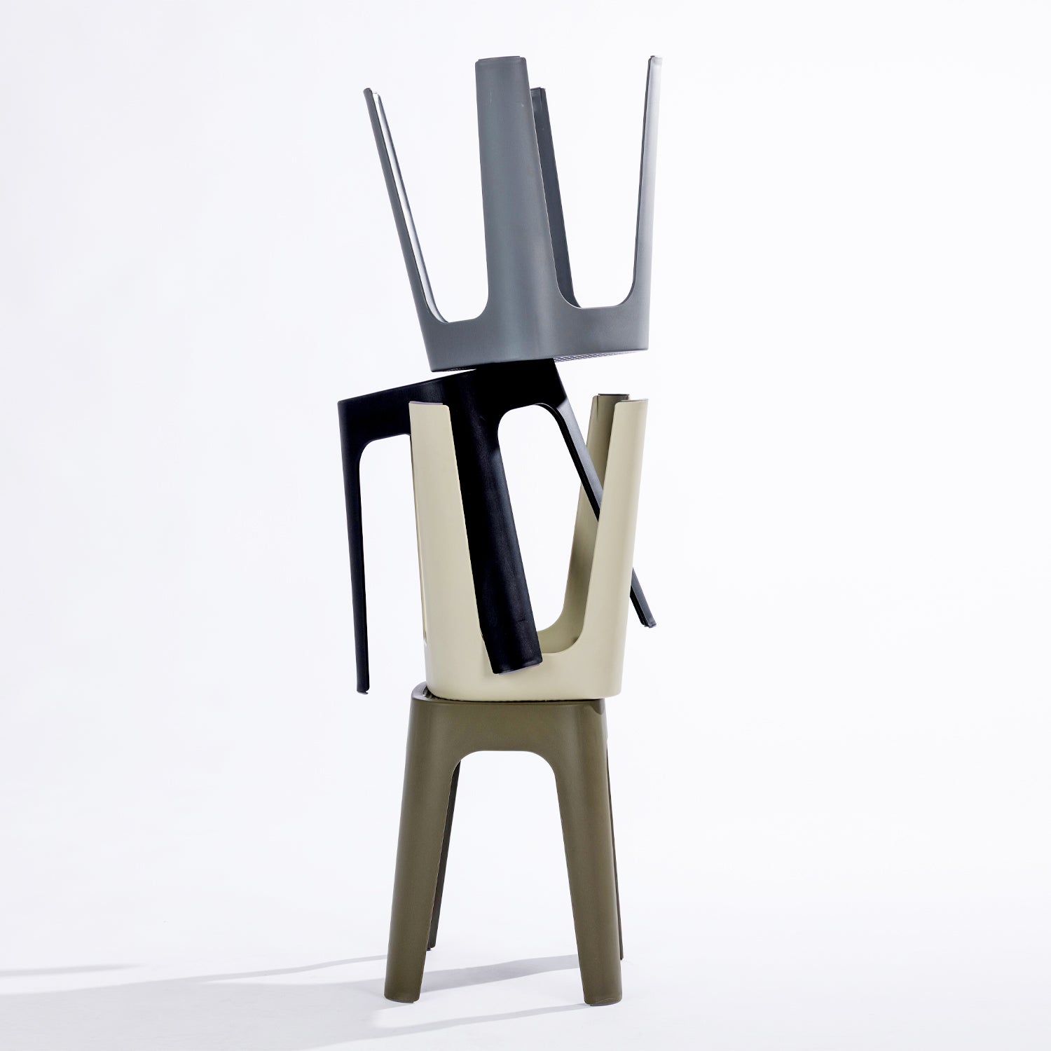 Four stools in black, stormy grey, olive & cream, stacked together on a clean white studio background.