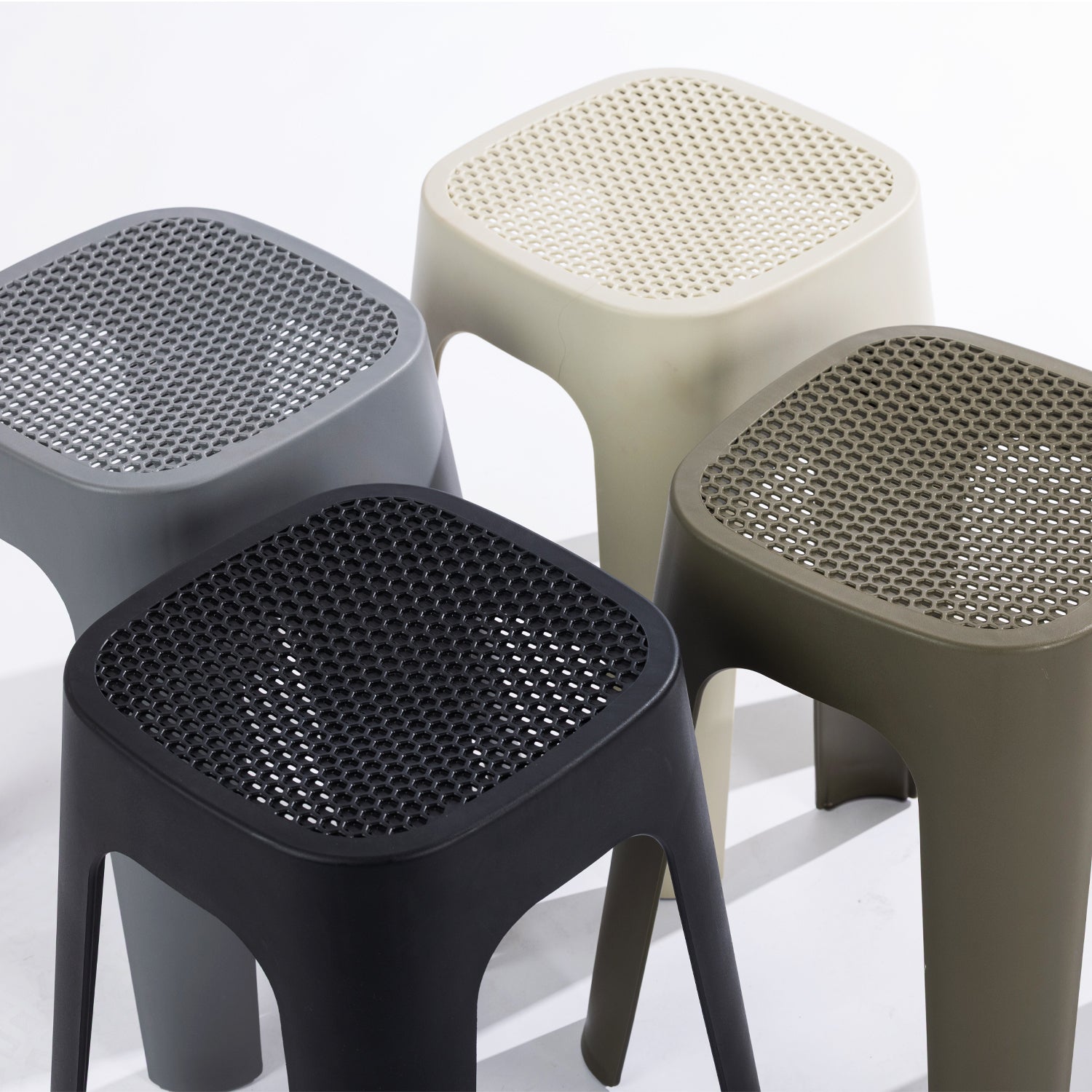 Four stools in black, stormy grey, olive & cream on a clean white studio background.