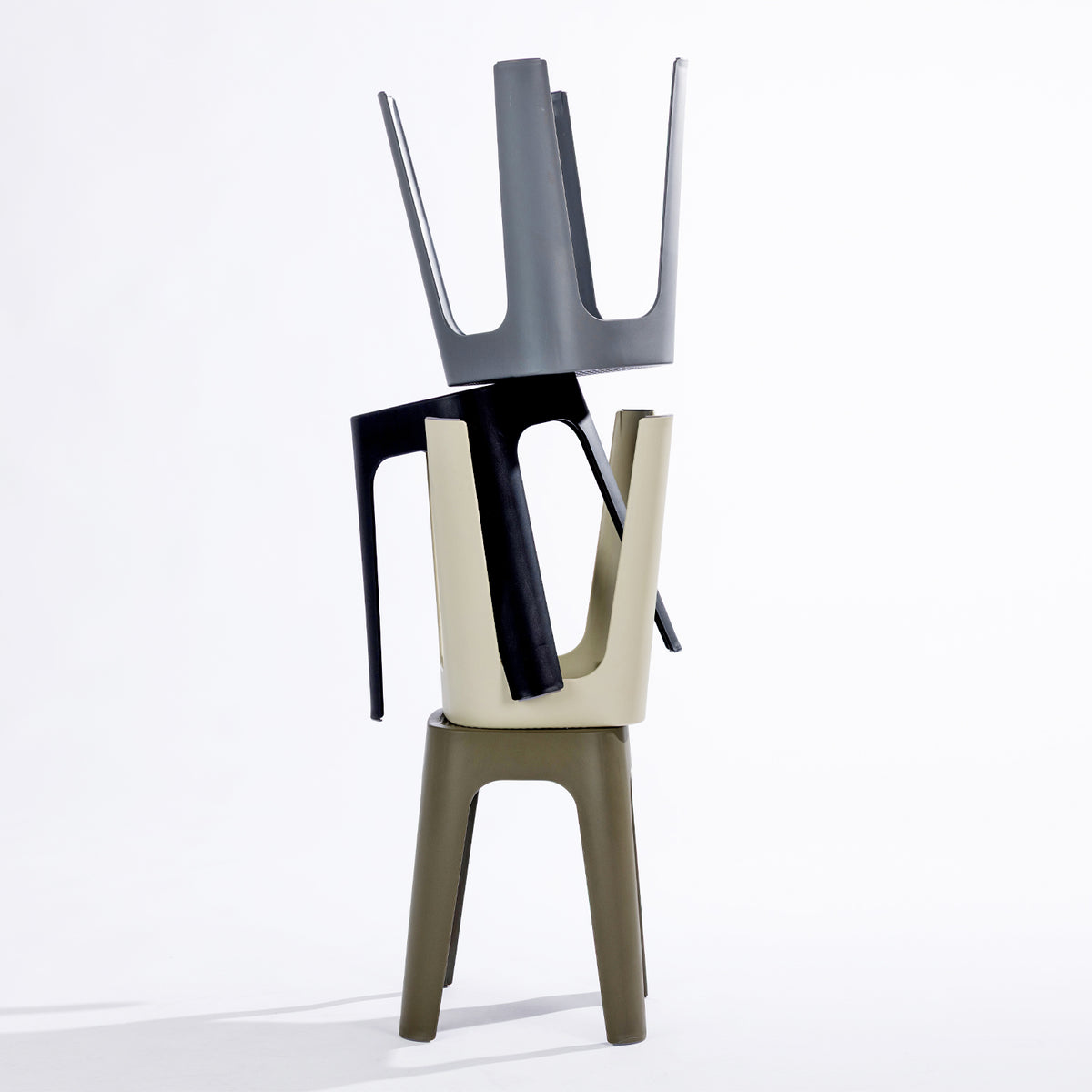 Four stools in black, stormy grey, olive & cream, stacked together on a clean white studio background.