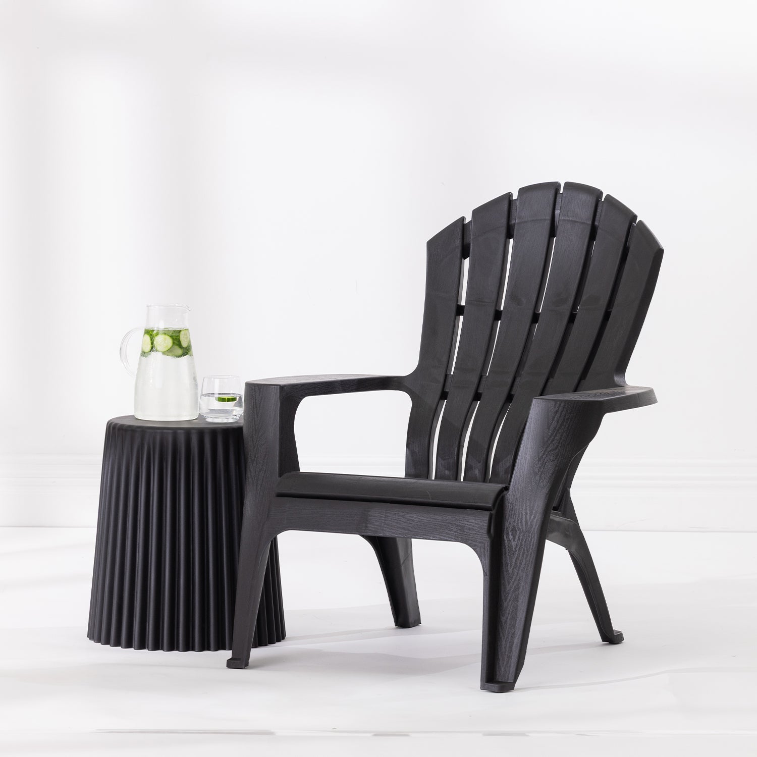 Black Cape Cod chair styled beside a Black side table with a glass jug and drinking glass against a bright white studio background.