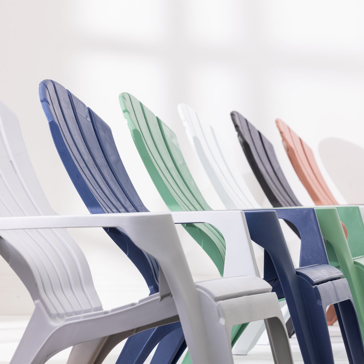 Cape Cod chairs in Navy, Green, Grey, White, Tan and Black arranged in a row against a white studio background.