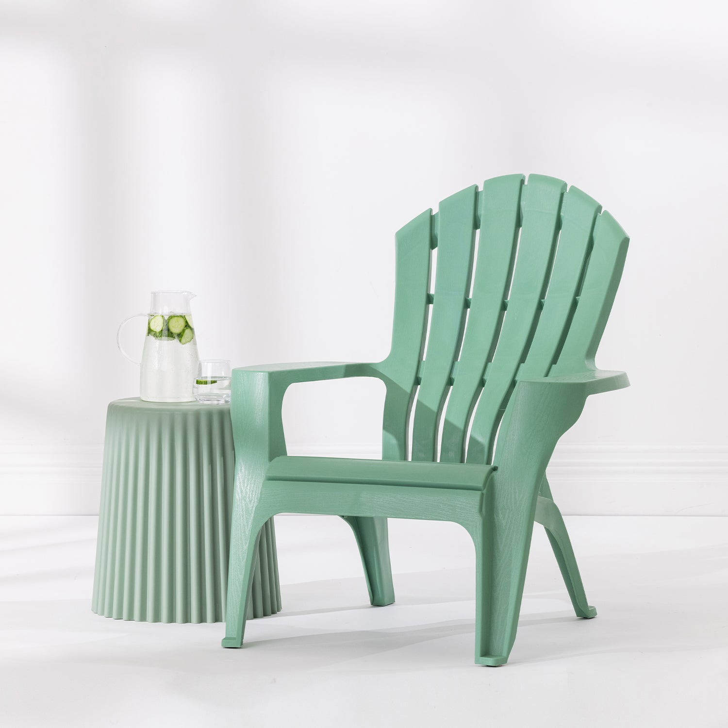 Green Cape Cod chair styled beside a Green side table with a glass jug and drinking glass against a bright white studio background.
