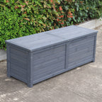 A charcoal wooden storage box, set outdoors on a concrete surface with green bushes in the background.