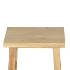 A close-up of a light natural wood stool or table top with two visible legs against a plain white background.