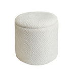 A cylindrical upholstered ottoman or stool with a textured,fabric in an cream color, shown against a plain white background.