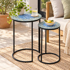 Outsidings Blue Tile Mosaic Side Table Set of 2 styled in a bright living space, featuring blue and green mosaic tabletops, black metal frames, a potted plant, drink and decorative bowl.