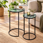 Outsidings Green Leaves Mosaic Side Table Set of 2 styled beside a neutral sofa, featuring tropical leaf-patterned tabletops, black metal frames, plants and decorative accessories.