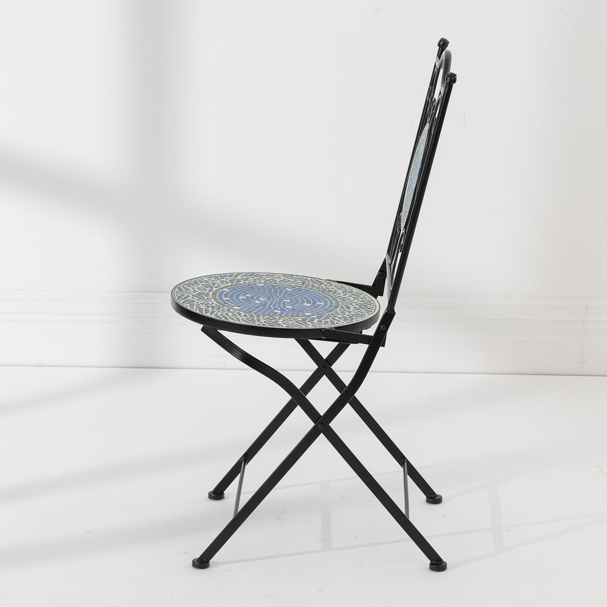 Side view of the Outsidings Blue Tile Mosaic Chair showing its folding black metal frame and circular mosaic seat.