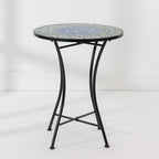 Outsidings Blue Tile Mosaic Table featuring a round blue and green mosaic top with curved black metal legs.