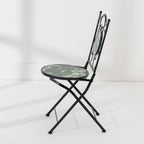 Side view of the Outsidings Green Leaves Mosaic Chair showing its folding black metal frame and mosaic seat.