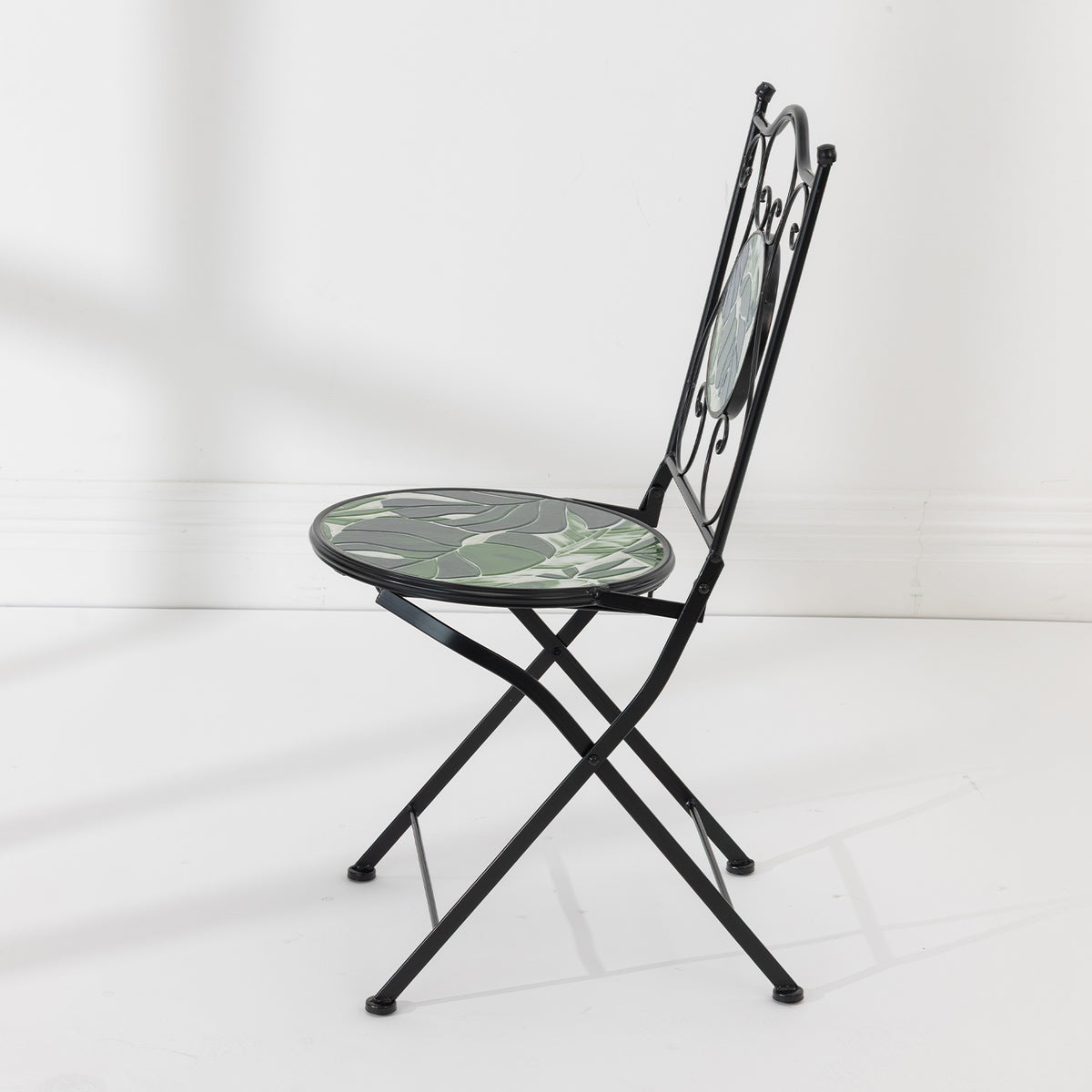 Side view of the Outsidings Green Leaves Mosaic Chair showing its folding black metal frame and mosaic seat.