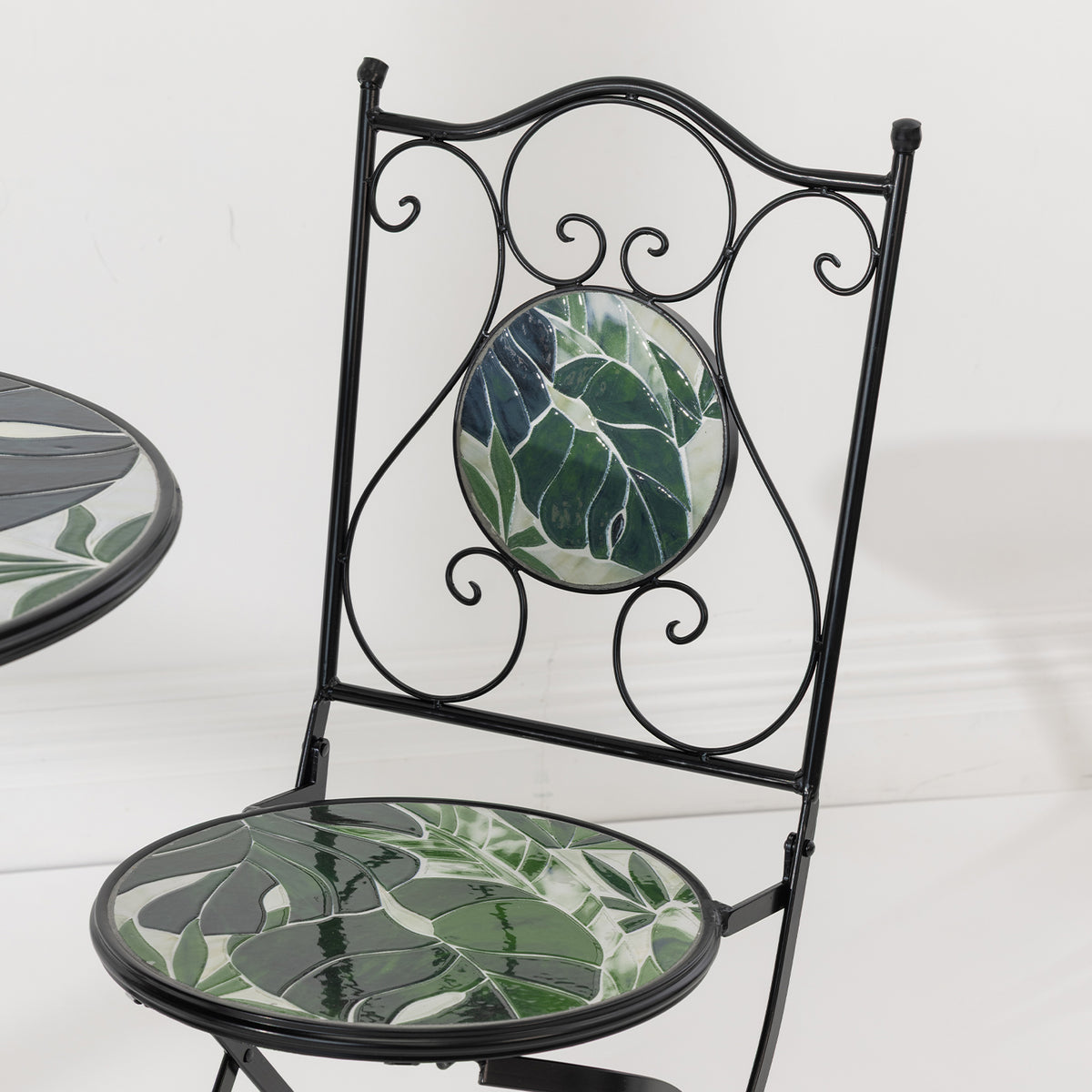 Close-up of the Outsidings Green Leaves Mosaic Chair showing the green leaf mosaic seat and decorative scrollwork backrest.