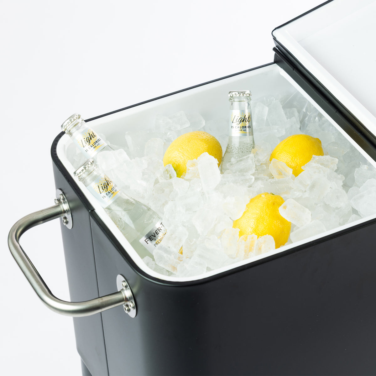 Close-up of the black cooler box's spacious white insulated interior, filled with ice, glass beverage bottles and lemons. The split-lid opening allows convenient access to chilled refreshments.