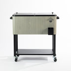 Grey wood-look 76L cooler box featuring a textured timber-effect exterior, black split lids with silver knobs, built-in bottle opener, side handles, bottle cap catcher, lower storage shelf and four caster wheels.