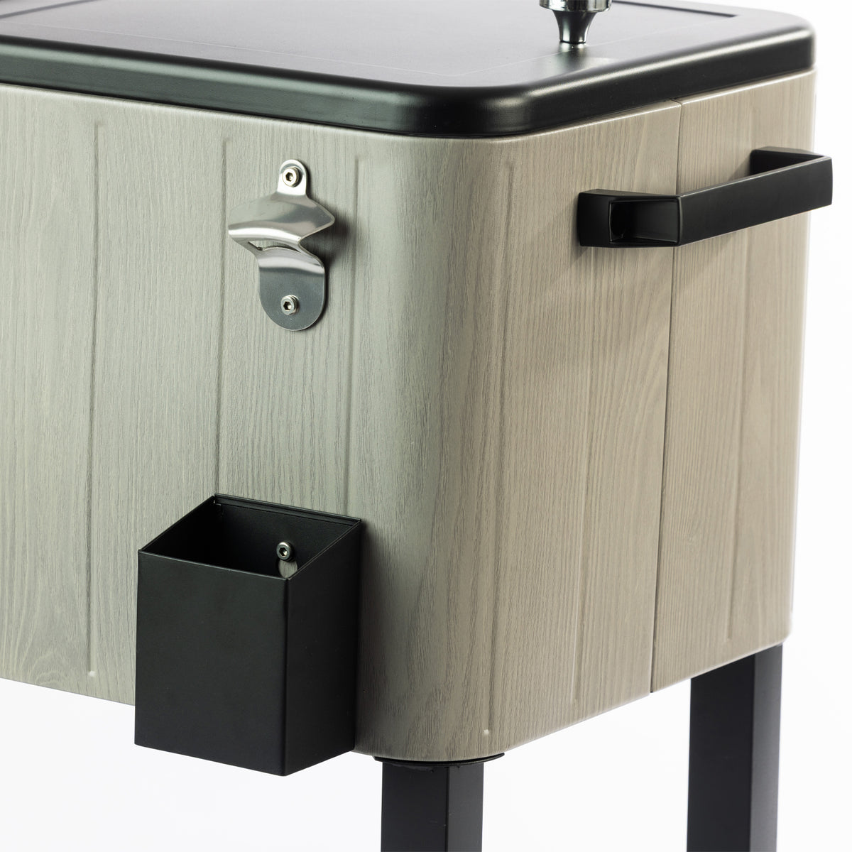 Detailed view of the cooler box's grey timber-effect finish, black side carry handle, silver built-in bottle opener and black bottle cap catcher mounted underneath.