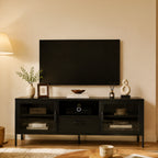 Black TV cabinet styled in a modern living room beneath a wall-mounted television, featuring glass doors, an open media shelf, central drawer and decorative accessories.