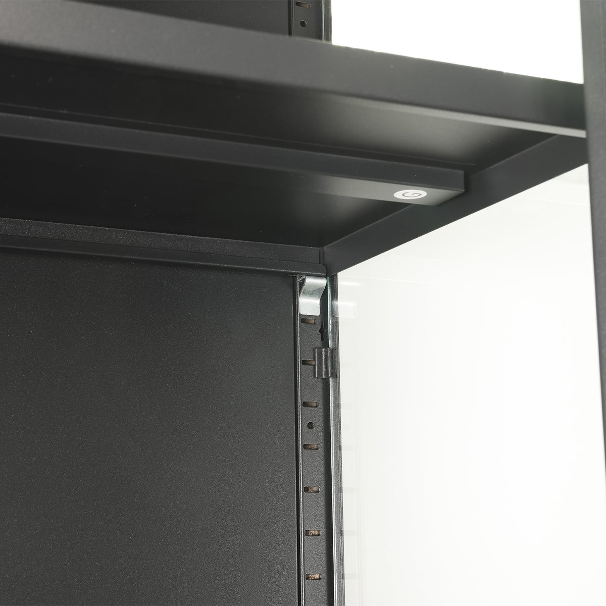 Close-up of the black TV cabinet's internal shelving, highlighting the shelf support rail and integrated lighting with touch control.