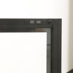 Close-up of the black TV cabinet's glass door frame, showing the magnetic door catch and fastening details.