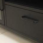 Close-up of the black TV cabinet's central drawer, highlighting the black horizontal handle and smooth finish.