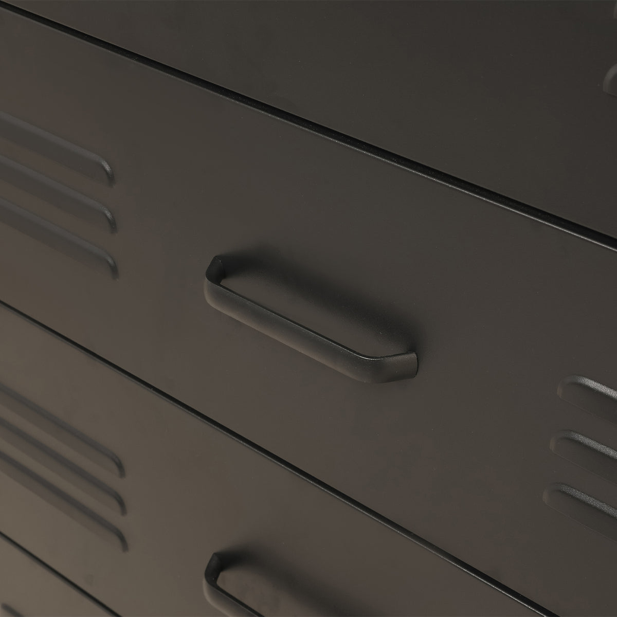 Close-up of a black metal drawer with a curved pull handle and ventilation slots on the side.