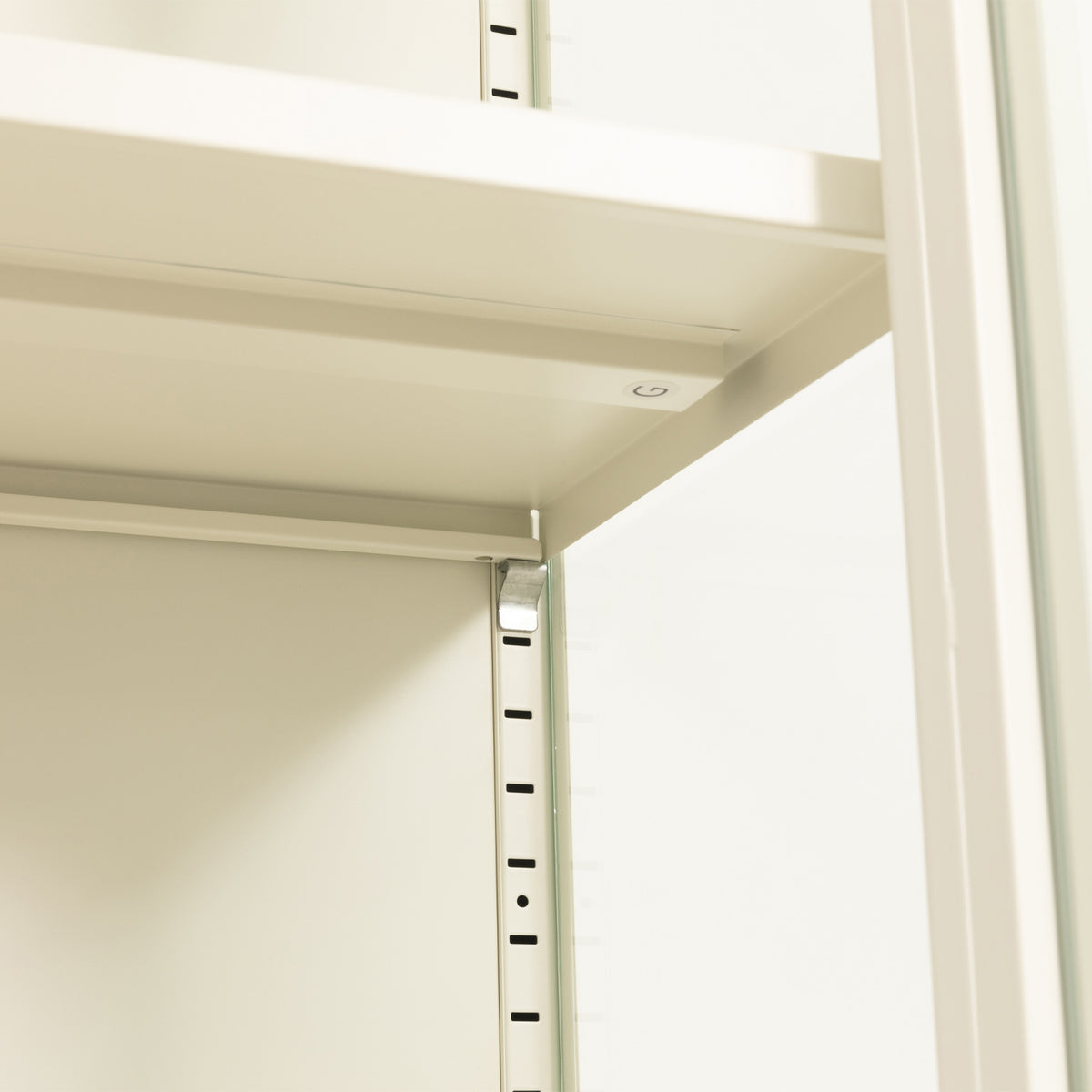 Close-up of a white adjustable shelving unit showing the shelf panel, mounting bracket, and vertical support rail.