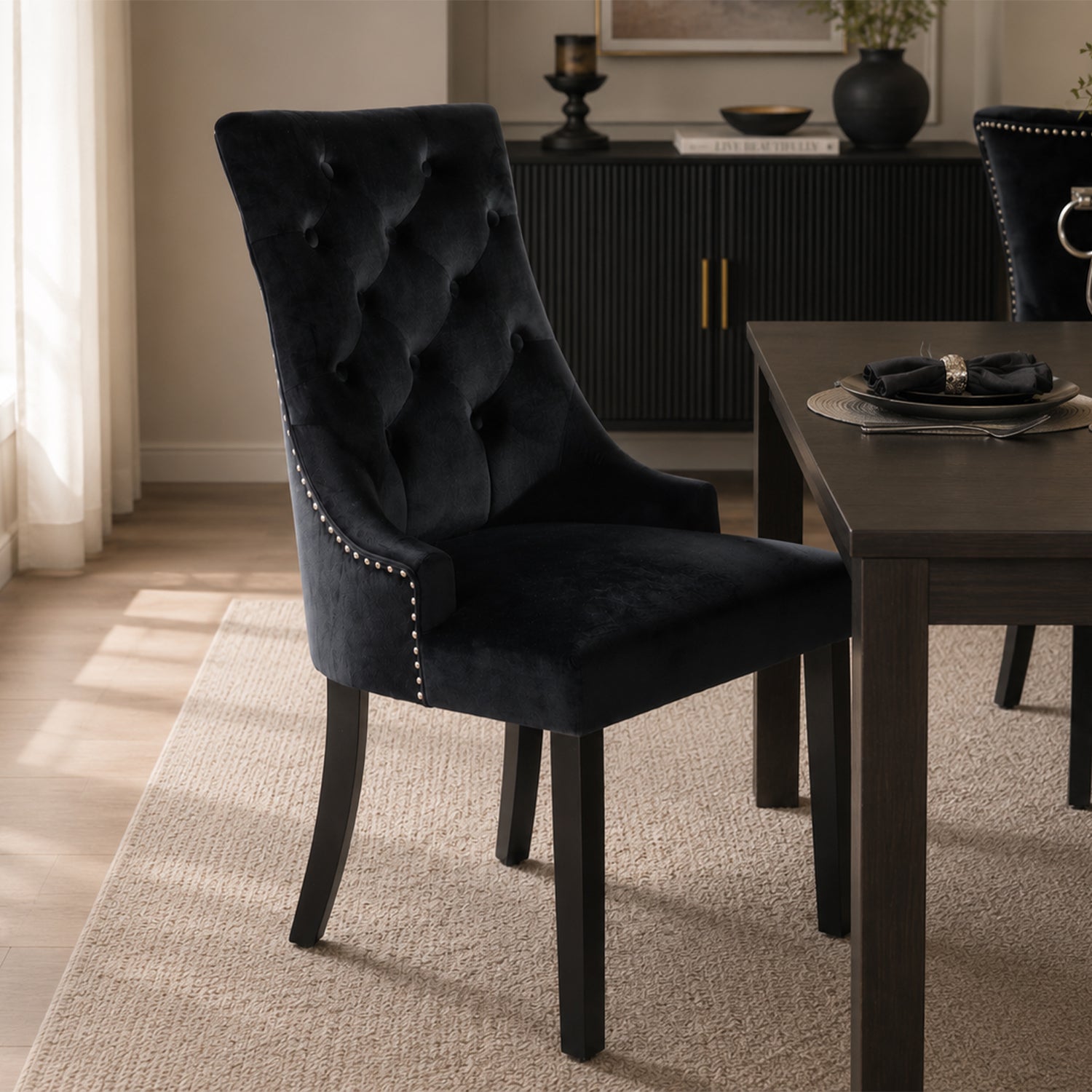 Design Republique Harvey Dining Chair in Black styled at a contemporary dining table, showcasing the button-tufted velvet upholstery, silver stud trim, and elegant high-back design.