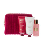 Rose & Berries body scrub, body lotion and body wash displayed in front of the matching berry-pink quilted cosmetic bag. The coordinated pink, burgundy and gold packaging gives the set a polished, gift-ready look.