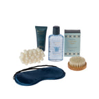 Grace & Gild Roman Spa Pamper Gift Set contents displayed on a white background, including body wash, hand and nail cream, bath salt, massage soap, wooden body brush and navy eye mask.