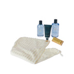 Grace & Gild Roman Spa Shower Gift Set contents displayed on a white background, including shampoo, body lotion, body wash, cream hair drying cap and wooden brush.