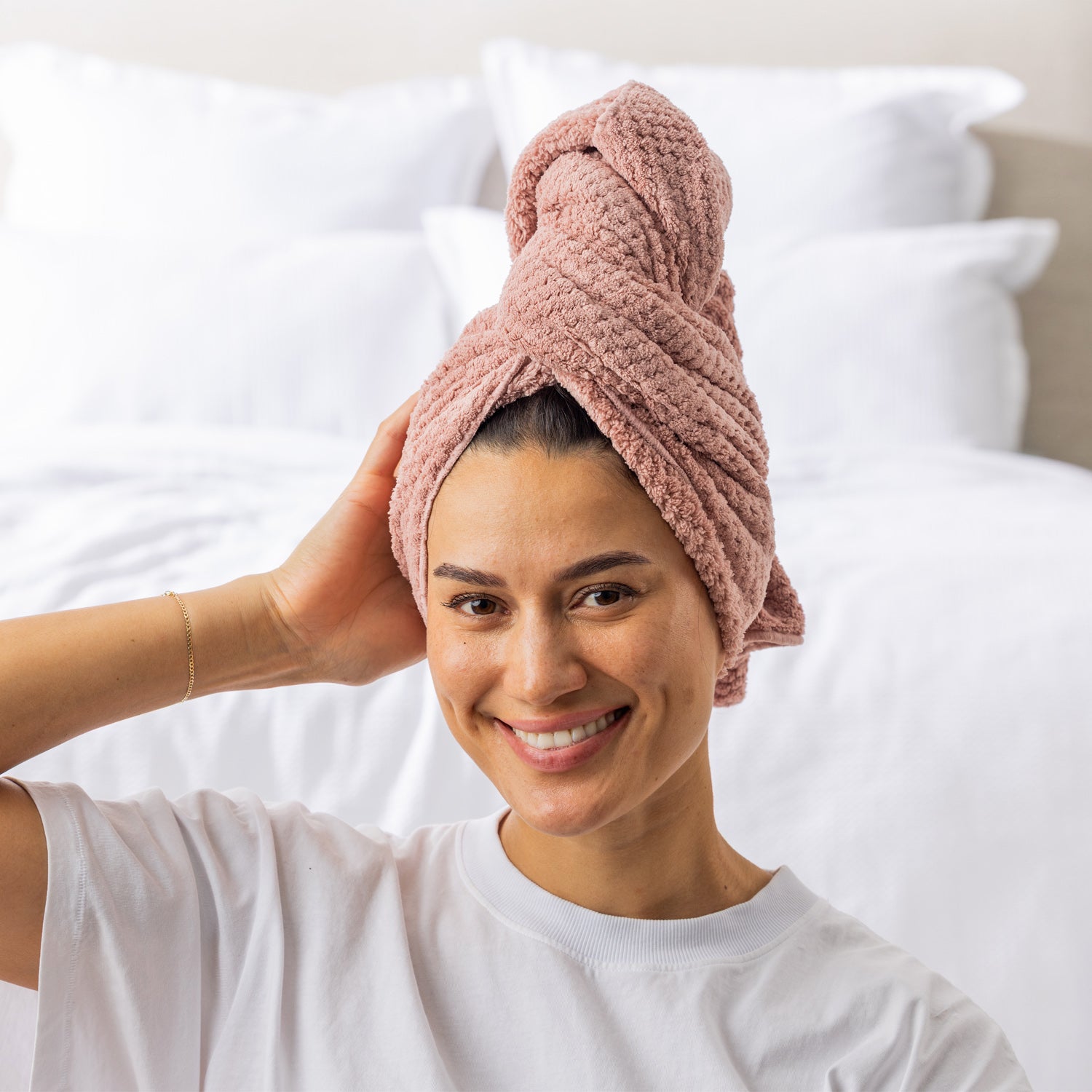 Grace & Gild Clementine Textured Hair Wrap in Light Pink, shown on a model from the front in a soft bedroom setting.