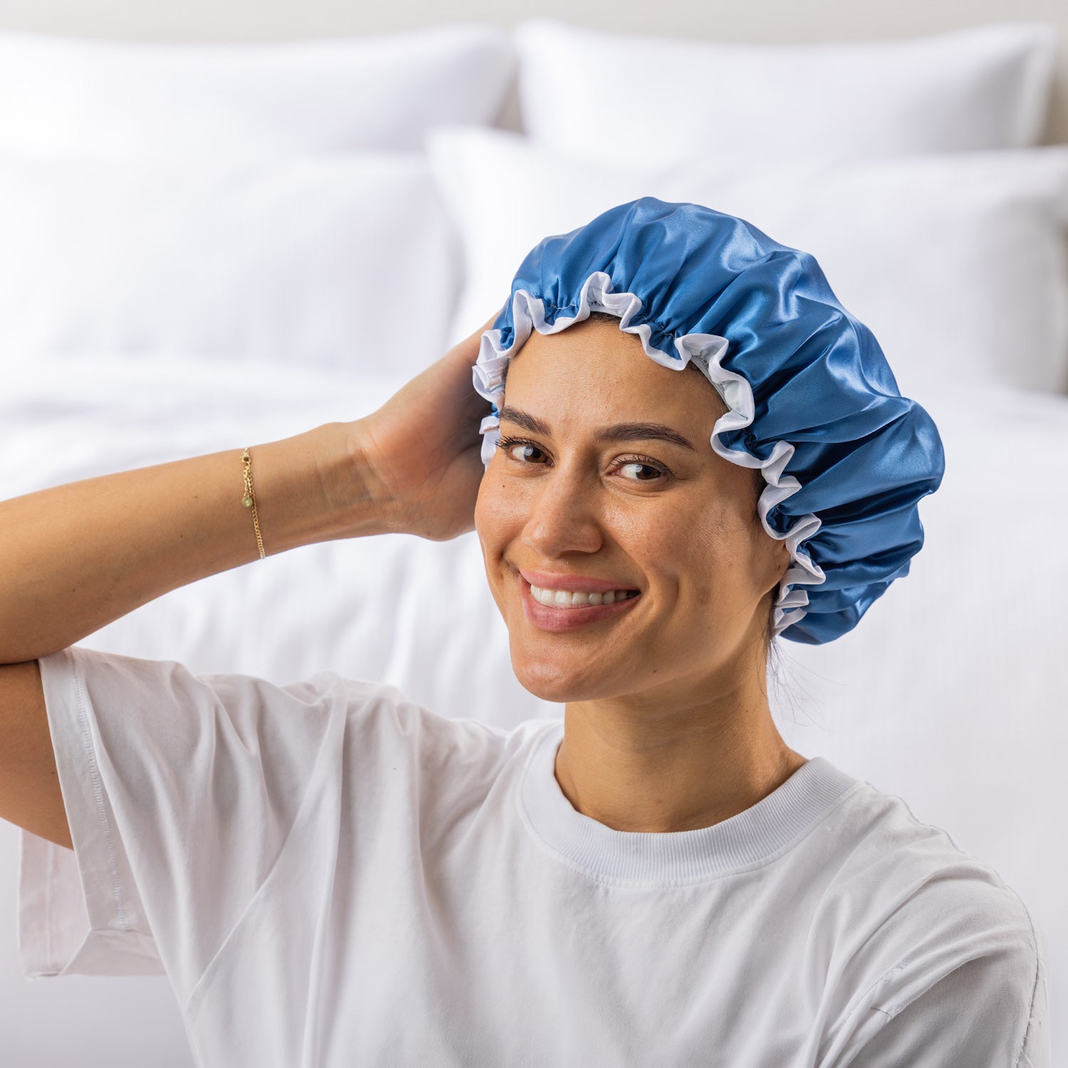 Grace & Gild Freya Pamper Set in Blue, showing a model wearing the blue satin shower cap.