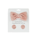 Grace & Gild Sophie Bow Headband & Cuff Set in pink, displayed in retail packaging with a plush bow headband and matching wrist cuffs.