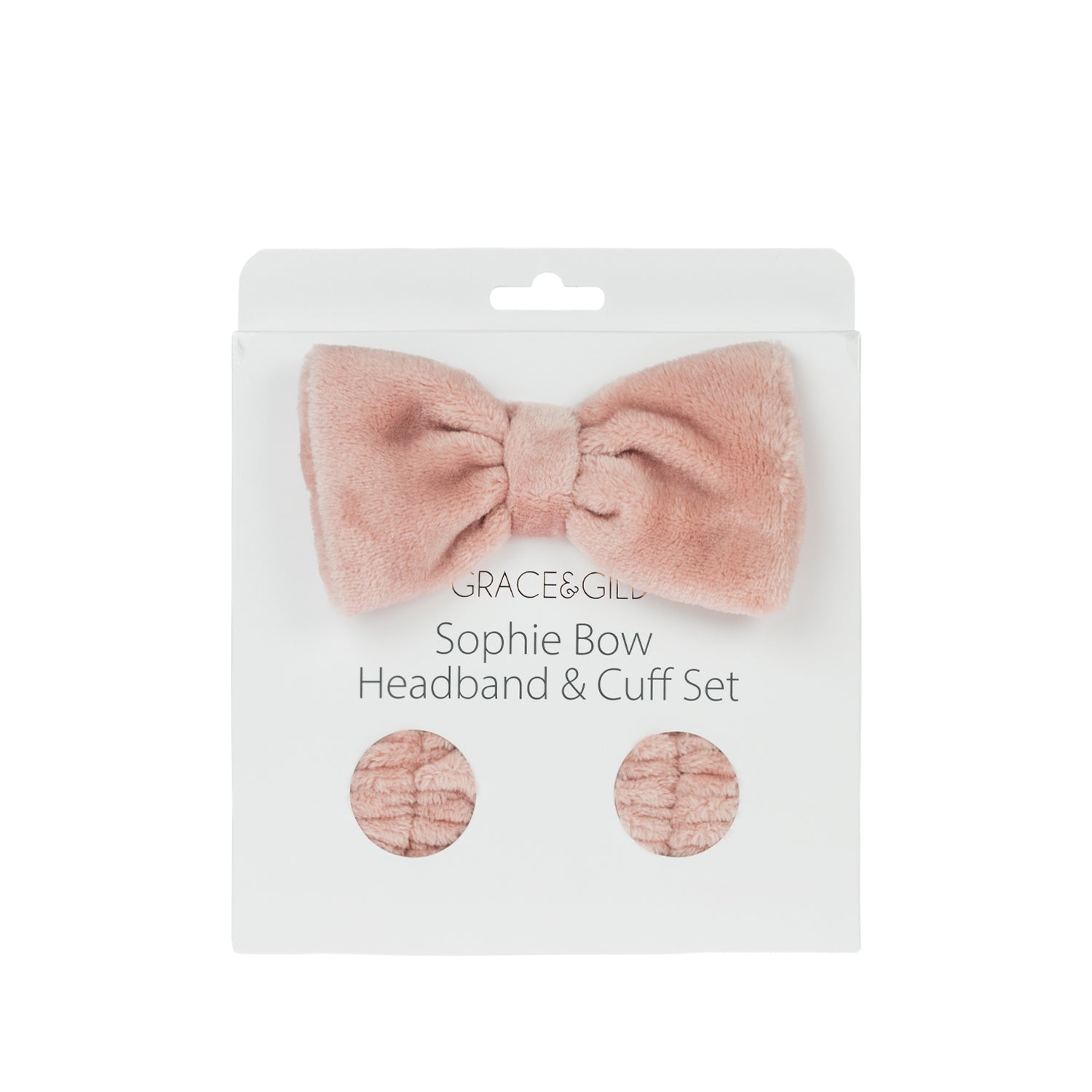Grace & Gild Sophie Bow Headband & Cuff Set in pink, displayed in retail packaging with a plush bow headband and matching wrist cuffs.