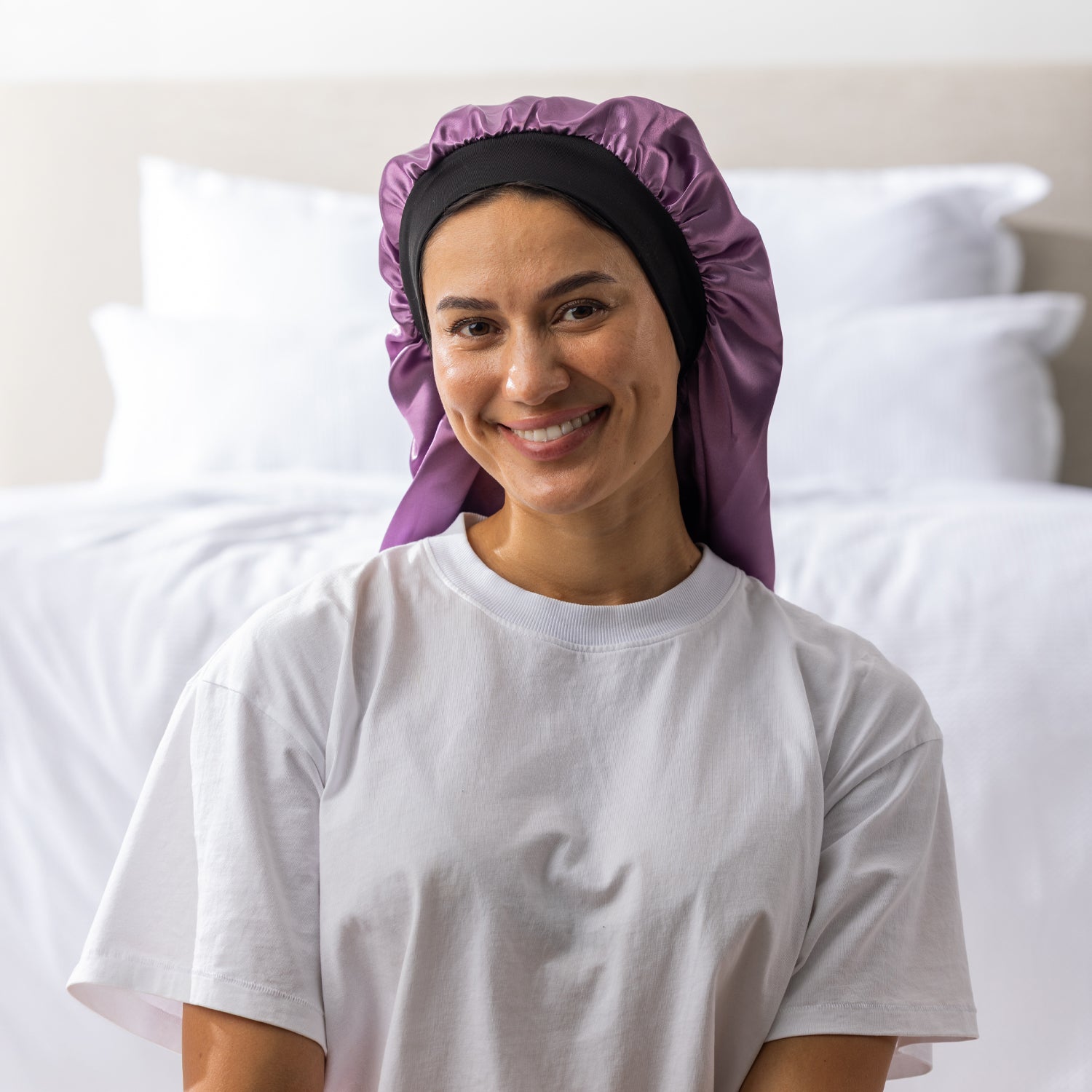 Woman wearing the Grace & Gild Long Sleep Bonnet in mauve with a wide black band.