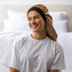 Woman wearing the Grace & Gild Long Sleep Bonnet in light brown with a wide black band.