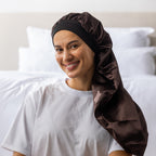 Woman wearing the dark brown Grace & Gild Long Sleep Bonnet with the long fabric section draped over her shoulder.