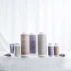 Eden Rose, Gardenia and Orchid scented talcum powder and hand cream range displayed together against a soft white curtain backdrop.