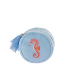 Sky blue round jewellery organiser featuring a soft textured finish, embroidered pink seahorse design, gold-toned zip and decorative blue tassel.