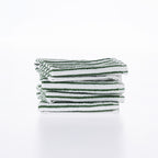 A neatly folded stack of white cotton dishcloths with fine green stripes is presented against a clean white background, highlighting their soft texture and classic design.
