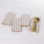 Gather Scallop Vichy Check napkin 4 pack in Brown/Cream arranged on a white table, with one napkin styled with gold-toned cutlery.