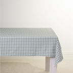 Gather Vichy Checks tablecloth in Green/Ivory draped over a white dining table.