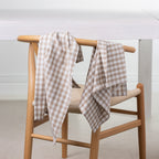 Gather Vichy Checks tea towels in Brown/Cream draped over the back of a wooden dining chair.